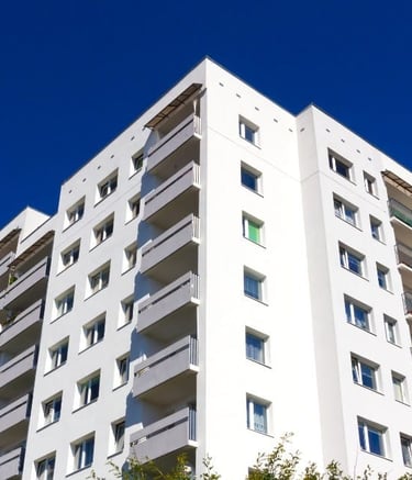 a tall white building with a blue sky in the background