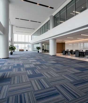 A professional wide-angle shot of a modern Riyadh office building interior featuring high-quality grey and blue carpet tile installation. The lighting is bright and professional, showcasing the clean seams and texture. The color palette includes #1C2833 and #9DAAB6. The mood is efficient and high-end.