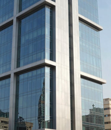 Professional photography of a modern commercial building in Riyadh with a sleek glass and aluminum facade. Middle Eastern / Gulf architectural context. Bright daylight reflecting off the clean, blue-tinted glass panels, emphasizing professional craftsmanship and modern urban design.