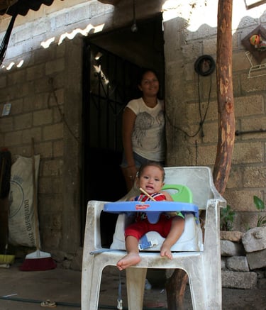 a baby in a chair with a woman standing next to her