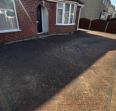 Removing dirt and stains from brick weave driveway with pressure washing in Norwich Norfolk
