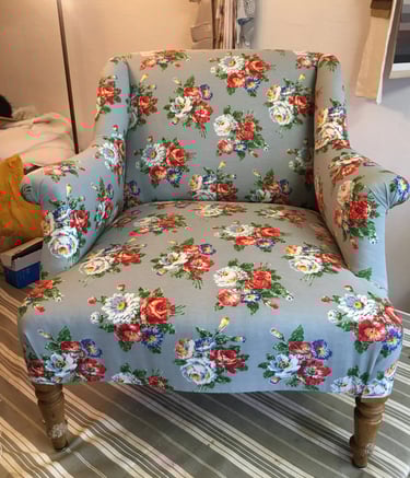 Fauteuil confortable de style anglais recouvert de tissu bleu à motif floral blanc et rouge