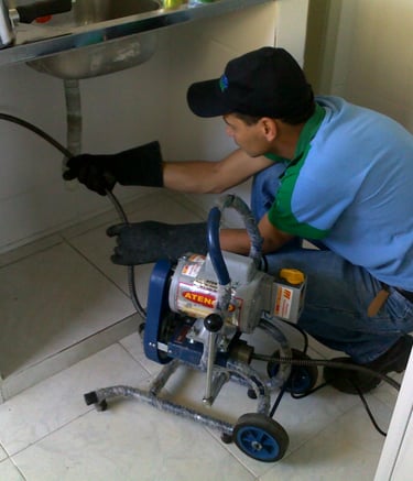 a man in a blue shirt is fixing a sink