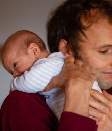 a man holding a baby in his arms