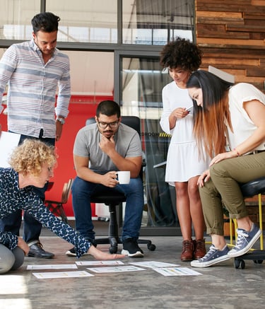 Équipe concentrée autour d’un travail collaboratif au sol lors d’un atelier Eureka.