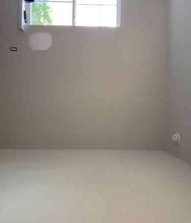 Old white walls with patched hole
