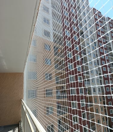 Close-up of a sturdy safety net protecting a playful dog on a balcony.