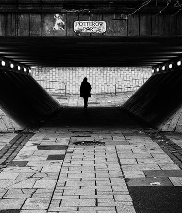 A solitary figure, in silhouette, walks through the underpass at Potterow, Edinburgh
