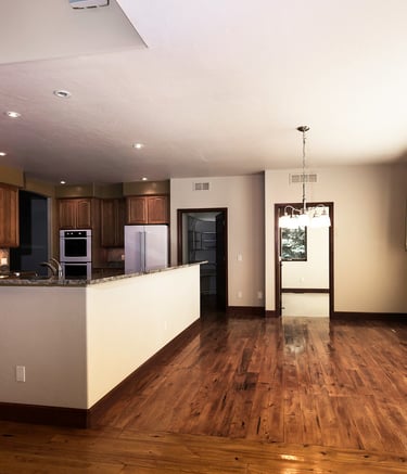 a kitchen with a wooden floor and a large window