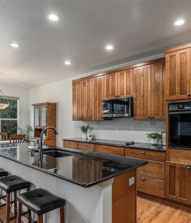 a kitchen with a large island and a clock on the wall