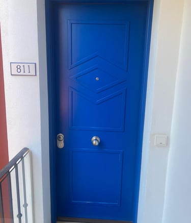 Vibrant blue apartment front door featuring geometric patterns and number 811 plate.