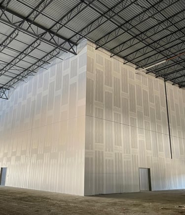 a large white wall where you can see that work is being done smoothing the walls of a commercial job