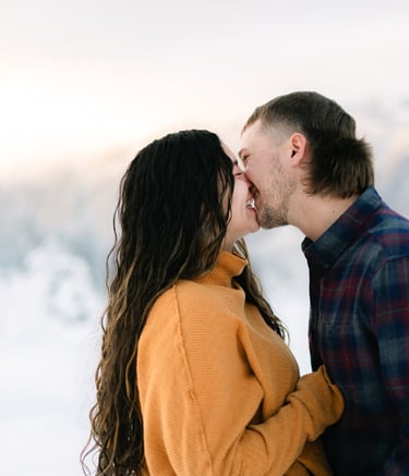 a man and woman kissing in the snow