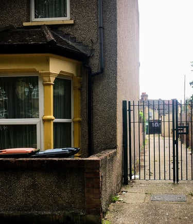 An end of terrace hous with yellow front and side entrance