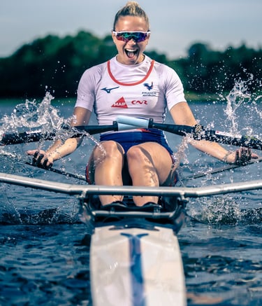 Portrait dynamique d’une athlète en action sur un skiff au milieu des éclaboussures