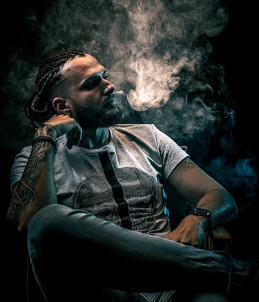 Portrait cinématographique d’un homme assis dans la fumée sous une lumière dramatique