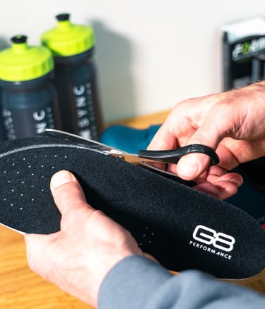 A bike fitter trimming some insoles
