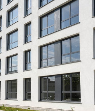 A wide-angle architectural shot of a modern residential building in Bulgaria with large, high-quality PVC windows, clean white walls, bright daylight, reflecting a professional and reliable company image.