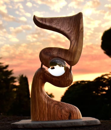 escultura abstracta de madera con una esfera de cristal en el centro