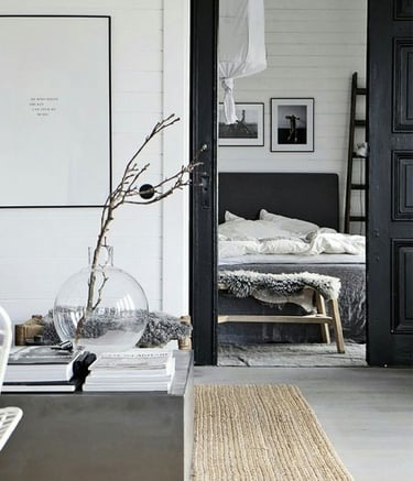 Interior decorado con tonos negros y blanco, distribuidor y dormitorio