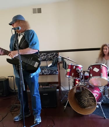 a man playing guitar in a room with a woman