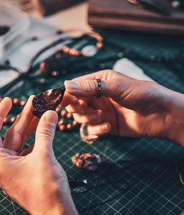 Manos observando una piedra preciosa para realizar una joya.