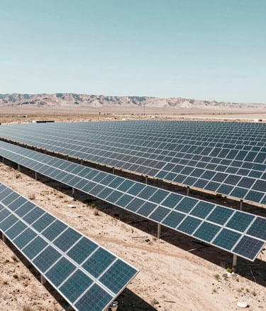 A large-scale solar array in an arid North American valley, bright midday sun, rows of panels stretching toward the horizon. Professional photography with clean lines and teal and off-white tones.