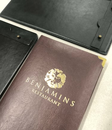 Custom leather menu covers and check presenters with gold foil restaurant logo.