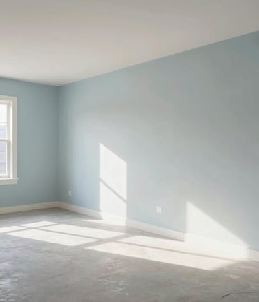 A wide-angle professional photograph of a freshly drywalled, spacious room in a contemporary North American / US home. The walls are perfectly smooth and the room is filled with natural sunlight. Muted Blue and Pearl Grey tones dominate the clean, airy space, emphasizing precision and modern craftsmanship.