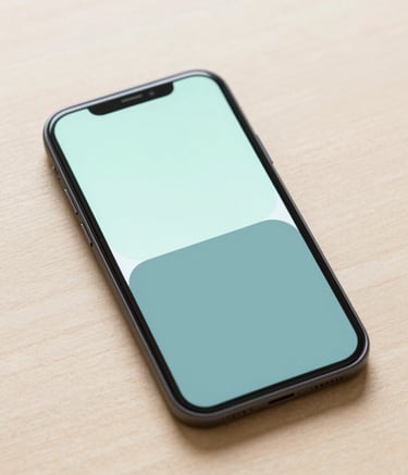 A close-up, high-angle shot of a minimalist Android smartphone resting on a clean, light wood surface. The screen shows a simple, elegant UI with soft #9CC0B9 and #4A6D7C color blocks. Modern, professional studio lighting with soft shadows, embodying the modern and clean mood of FAINABUD.