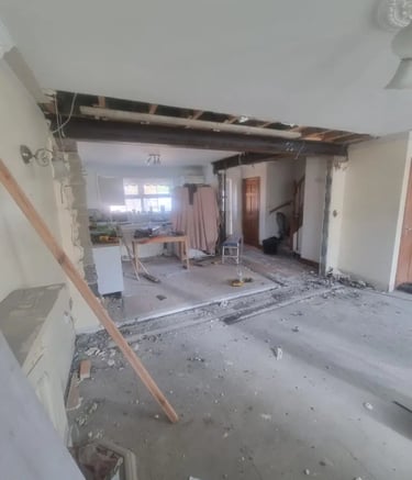 Open plan home renovation showing a structural steel beam installation and wall removal in a house.