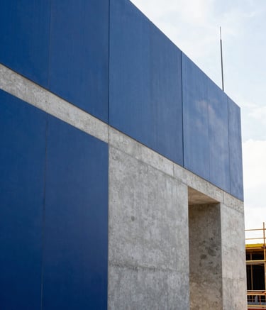 A professional South American construction site scene, showing a clean, newly built structural wall. The lighting is bright and natural. The palette features midnight blue and concrete grey tones, highlighting a modern and precise aesthetic.