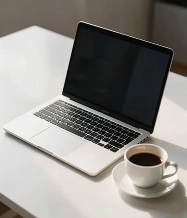 A conceptual, minimalist photograph representing the evolution from technology to humanism. A sleek silver laptop sits next to a warm cup of coffee on a white desk, bathed in soft morning light, creating a professional yet inviting scene.