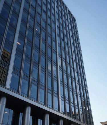 An exterior wide shot of a sleek, modern architectural building in a North American / US city financial district. The building features glass and steel with Midnight Blue reflections of the sky and Silver Grey structural accents, exuding trustworthiness.