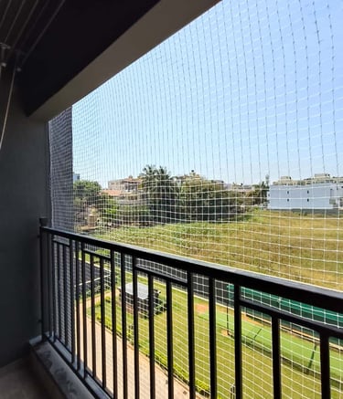 Close-up shot of sturdy pigeon netting stretched over a balcony railing, bright sunlight highlightin