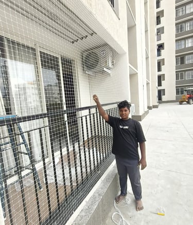 Technician carefully installing a pigeon net on a balcony railing in Thane East.