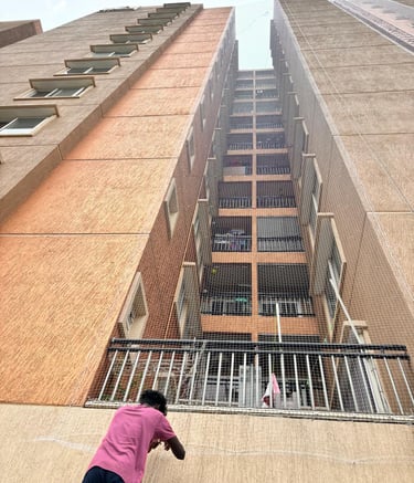 Wide shot showing a high-rise apartment with pigeon nets covering all balconies.