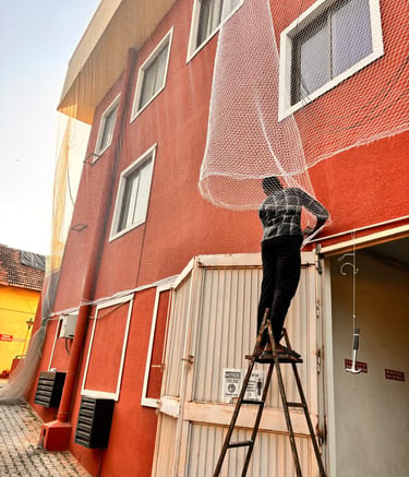 Technician installing pigeon netting on a busy T Nagar balcony