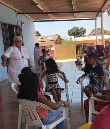 A healthcare worker in a white uniform assists children at a community health clinic in Brazil.