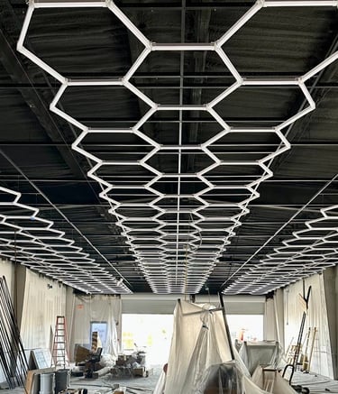Custom honeycomb LED lighting installation over black industrial exposed ceiling