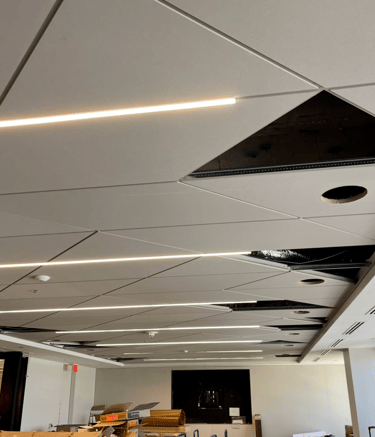 Modern geometric acoustic ceilings with linear LED lighting in Downtown Orlando.