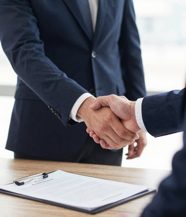 Smiling business partners shaking hands in a bright conference room