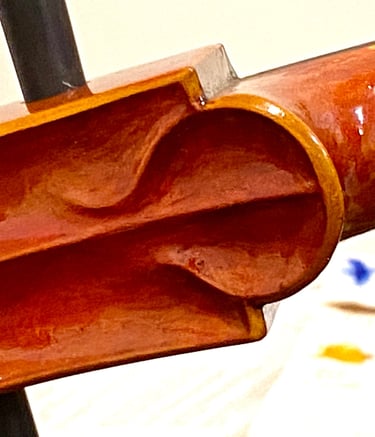 The 2024 cello "chin at the lower end of the scroll has creative, individualized detail.