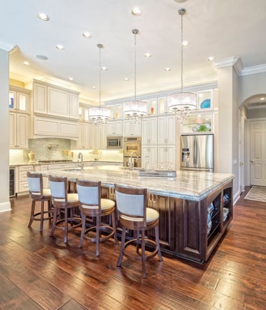 Elegant custom kitchen island with chandeliers and white cabinets in McHenry County build