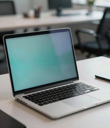 A close-up photograph of a sleek, high-end workstation in a North American / US Professional office. A laptop sits on a minimalist desk with soft teal and soft blue lighting reflections on the screen. The background is slightly blurred, showing a clean, modern workspace with a sophisticated atmosphere.