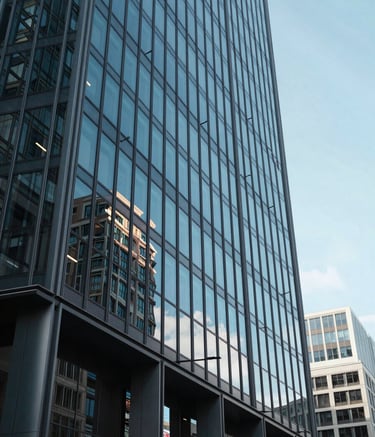 Photography of a sleek, modern glass office building in a major European financial district, low angle shot, bright daylight, midnight blue and soft steel blue accents in reflections, North American / European business context.