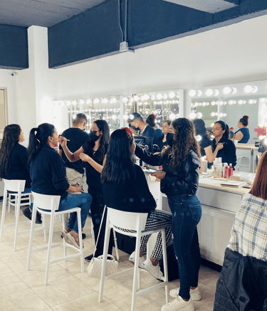 Maquilladores profesionales que aplican cosméticos a los clientes en un estudio luminoso con espejos