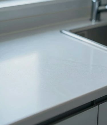 A macro photograph showing a clean, well-maintained modern North American / US kitchen countertop. The focus is on the spotless environment, conveying a sense of hygiene and protection. Lighting is bright and clinical. Palette includes Soft Steel Blue and Cloud Mist.