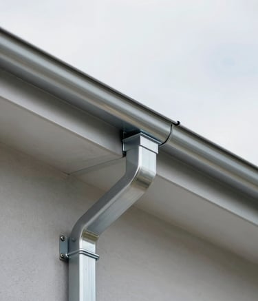 A close-up professional shot of a high-quality zinc gutter installation on a modern house roof. The metal is shiny and clean, showing precision joints and craftsmanship. Natural daylight, overcast sky for soft shadows. Includes colors #90A4AE and #455A64.