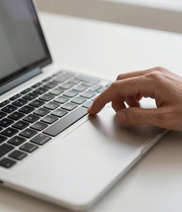 A detailed close-up of a person's hand using a trackpad on a sleek laptop in a bright, modern professional setting in North America, with a focus on clean design and productivity.